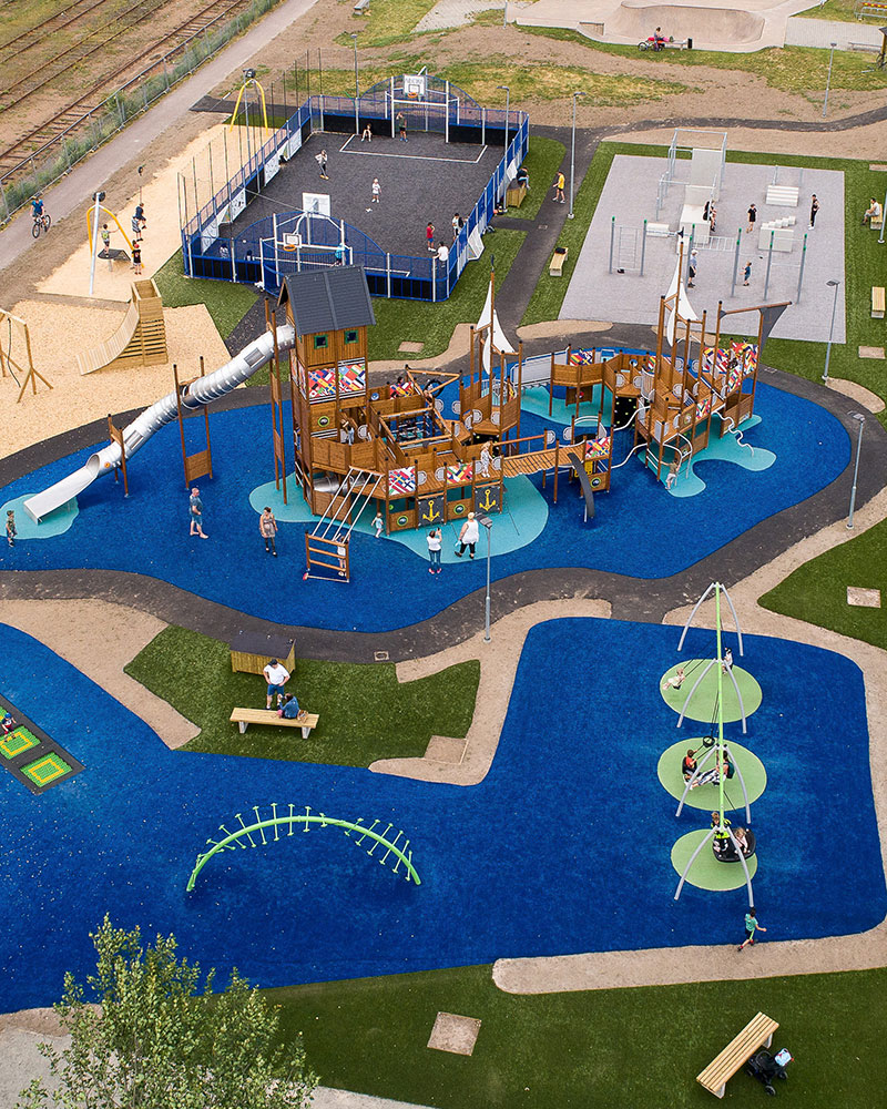 Ariel shot of a large playground, with wet pour surfacing showing color, excitement and clear pathways around the playground.